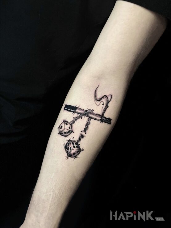 Tattoo Cigarette with dangling dice in objects motif and graphic / illustrative style On the arm