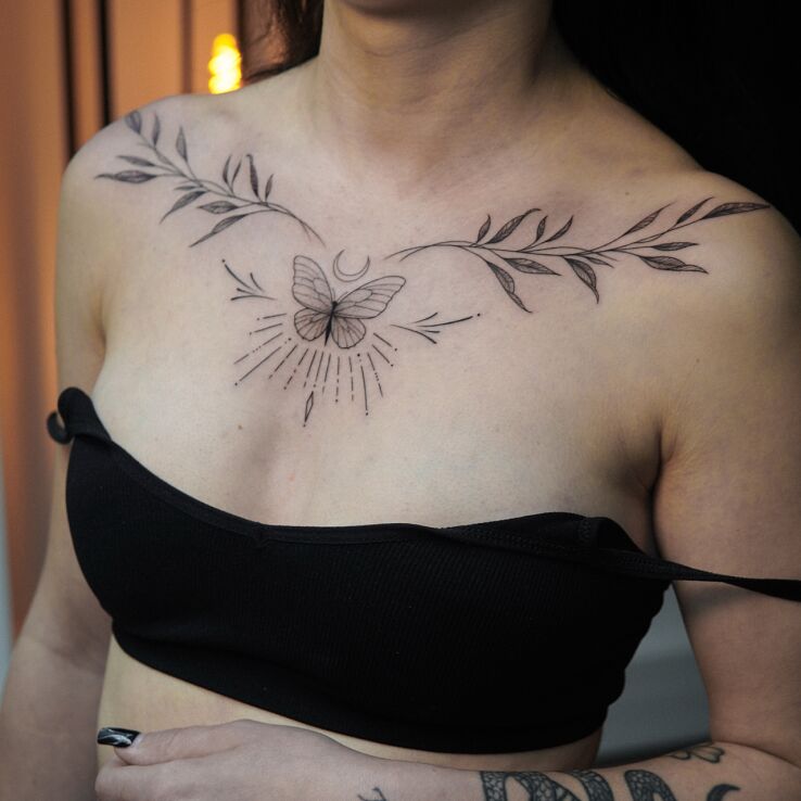 Tattoo Delicate butterfly and moon chest tattoo in black and gray motif and graphic / illustrative style on the collarbone