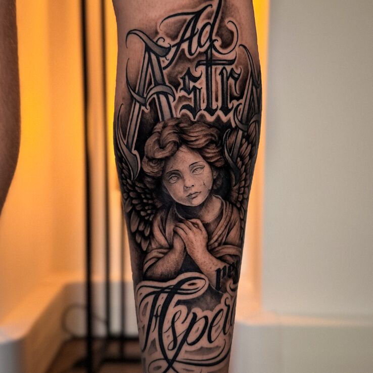 Tattoo Ad Astra Aspera – Angel and Chicano Lettering in religious motif and calligraphy style on the leg