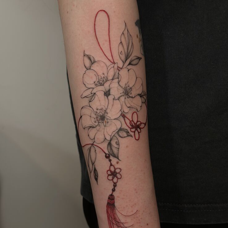 Tattoo Cherry Blossoms and Ornamental Tassel in flowers motif and sketch style On the arm