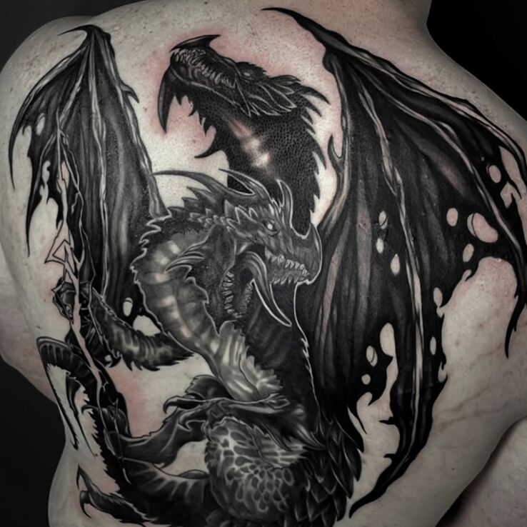 Tattoo Two powerful dragons across the entire back in black and gray motif and blackwork / blackout style on the shoulder blades