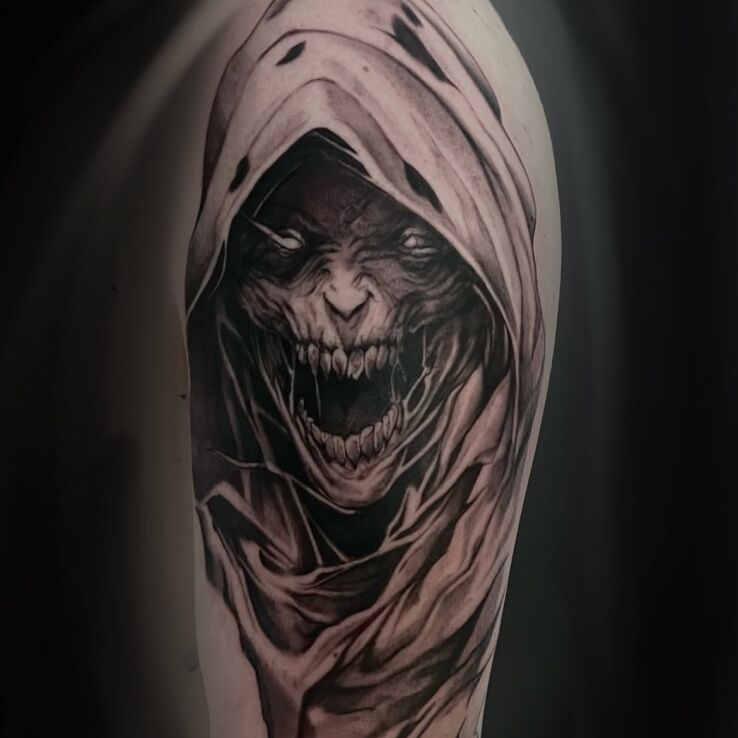 Tattoo Dark Hooded Figure in fantasy motif and graphic / illustrative style on the upper arm