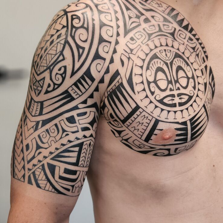 Tattoo Polynesian cage sleeve in characters motif and Polynesian style on the shoulder