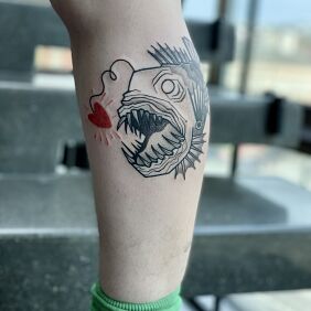 Tatuaż Ryba–potwór z czerwonym sercem na łydce motyw: zwierzęta styl: dotwork
