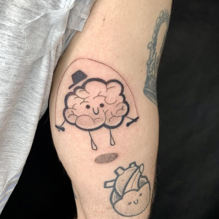 Tattoo Brain in cartoon form in characters motif and graphic / illustrative style On the arm