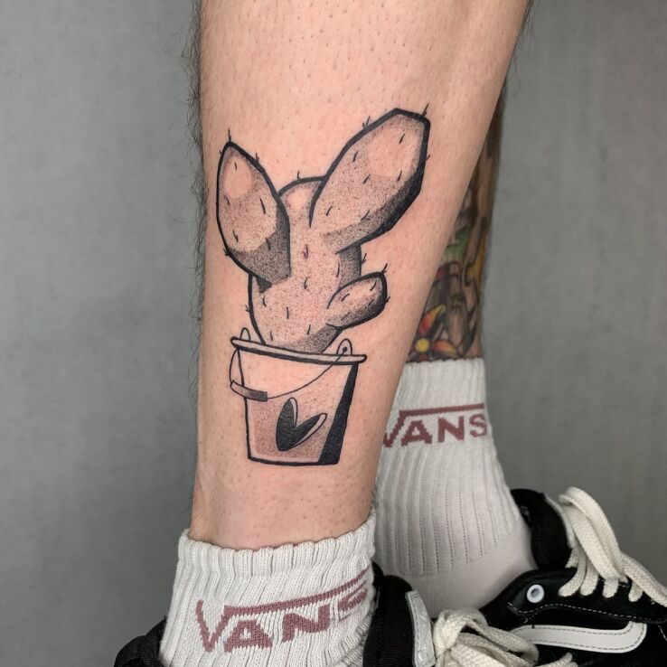 Tattoo Cactus in black and gray motif and graphic / illustrative style on the leg