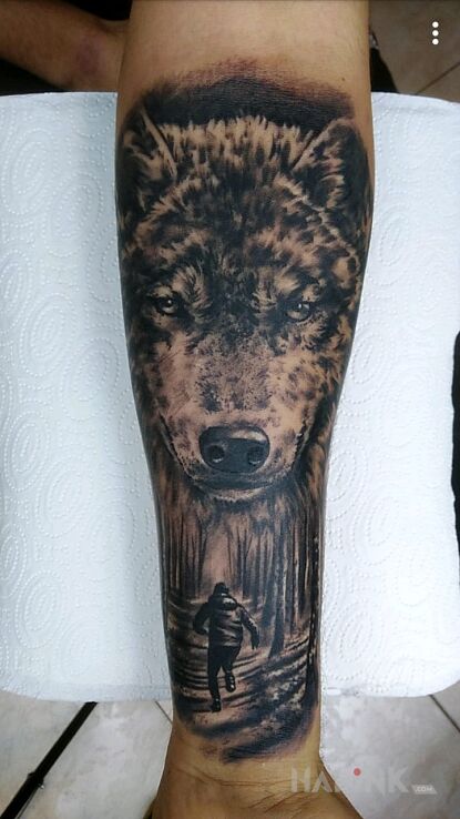 Tattoo Wilk czuwający nad chłopcem in characters motif and realistic style on the forearm
