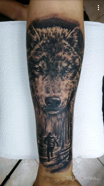 Tatuaż wilk czuwający nad chłopcem w motywie zwierzęta i stylu realistyczne na przedramieniu
