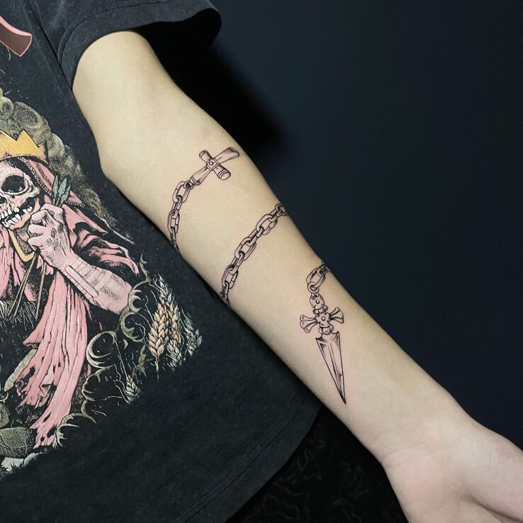 Tattoo Chain in the form of a rosary in black and gray motif and graphic / illustrative style On the arm