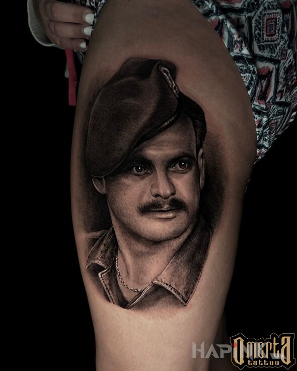 Tattoo Portrait of a man like a photo in black and gray motif and realistic style on the leg