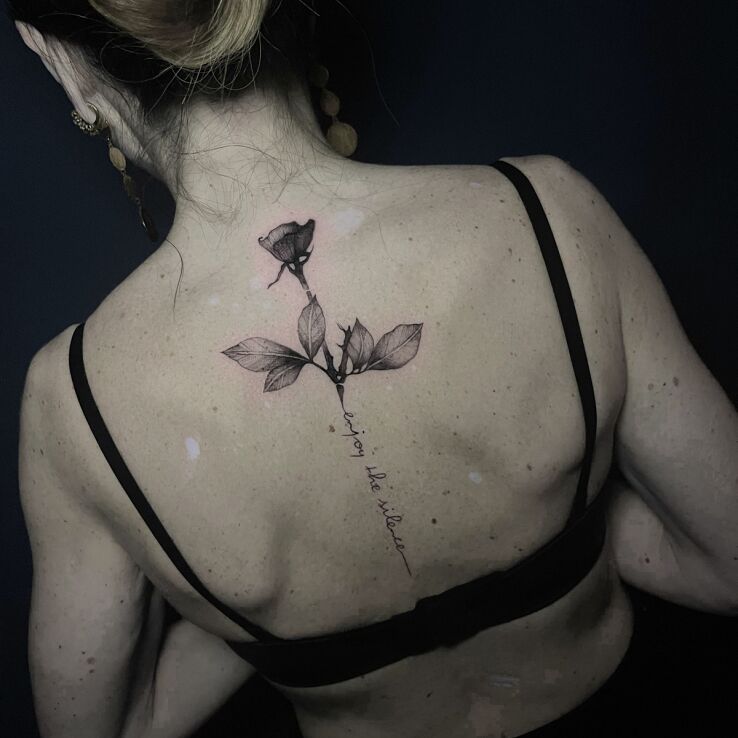 Tattoo Rose with inscription on the spine in black and gray motif and graphic / illustrative style on the back