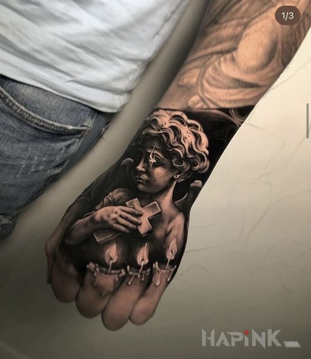 Tattoo Sad little angel in angels motif and realistic style on the hand