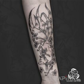 Tattoo Five-tailed fox surrounded by flowers on the upper arm motif: fantasy style: japanese / irezumi
