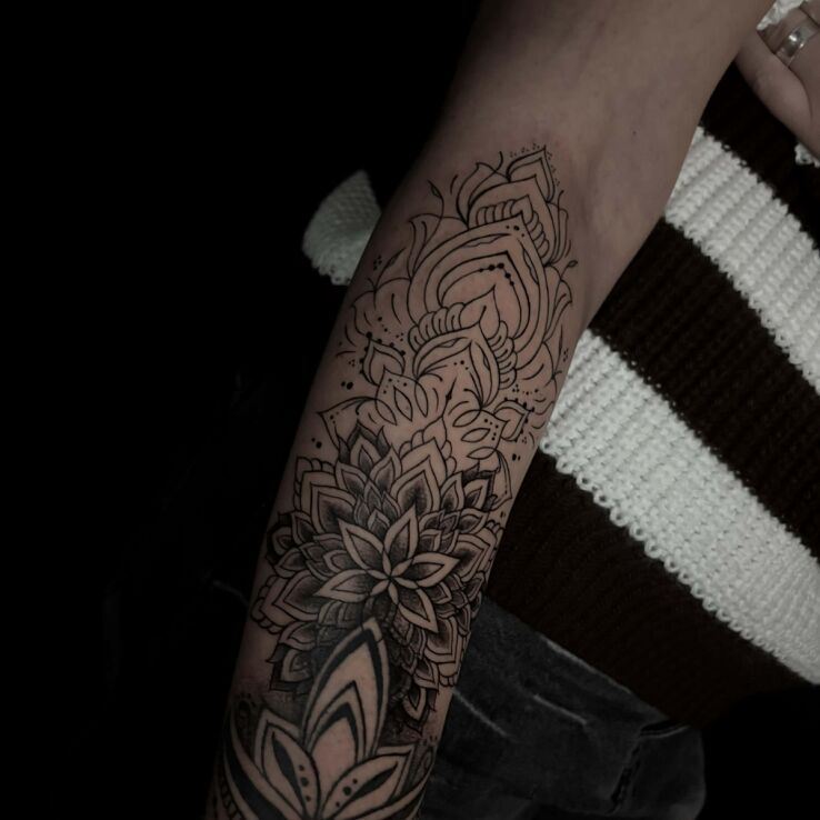 Tattoo Mandala combined with geometry in black and gray motif and graphic / illustrative style On the arm