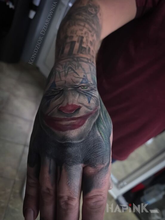 Tattoo Joker tattoo in colorful motif and realistic style on the hand