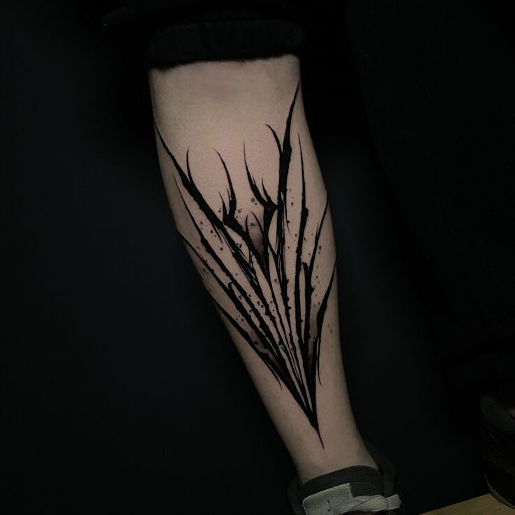 Tattoo Neotribal on the shin in black and gray motif on the tibia