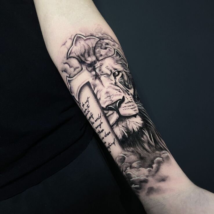 Tattoo Lion roaring in a cross against a cloudy background in black and gray motif and graphic / illustrative style on the forearm