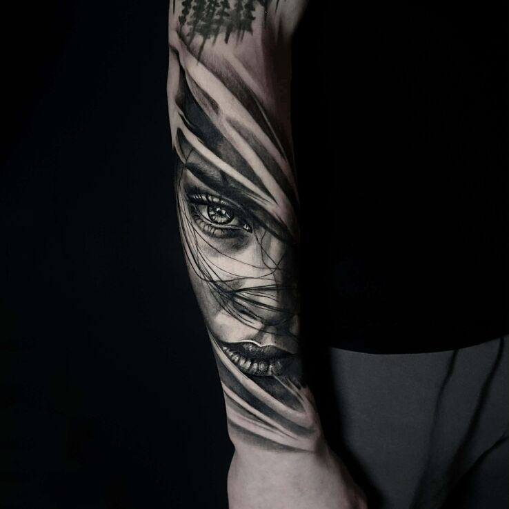 Tattoo Realistic female face with transitions in faces motif and abstract style on the forearm