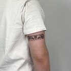 Realistic wolf eyes tattooed as a subtle arm band.