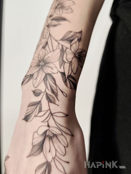 Tattoo Flowers in black and gray motif and graphic / illustrative style on the hand
