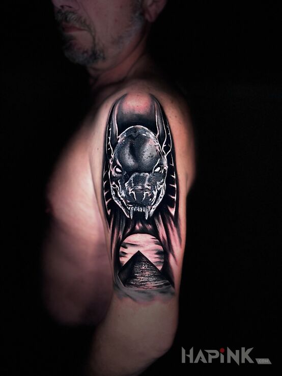 Tattoo Anubis in black and gray motif and realistic style on the upper arm
