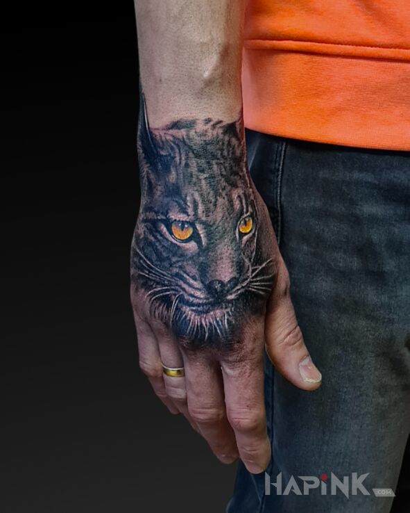 Tattoo Lynx in animals motif and realistic style on the hand