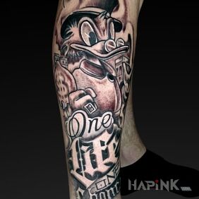 Tattoo Scrooge on the tibia motif: lettering style: calligraphy