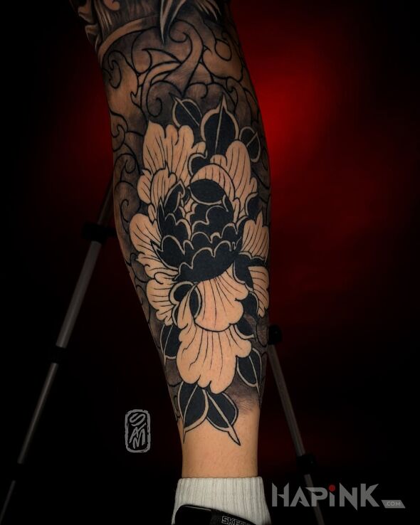 Tattoo Japanese Flower in black and gray motif and blackwork / blackout style on the leg