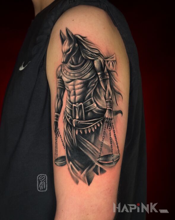 Tattoo Anubis in black and gray motif and realistic style on the upper arm