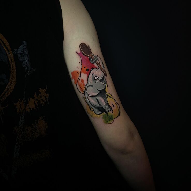 Tattoo Colorful elephant with a spoon in its trunk in colorful motif and graphic / illustrative style On the arm