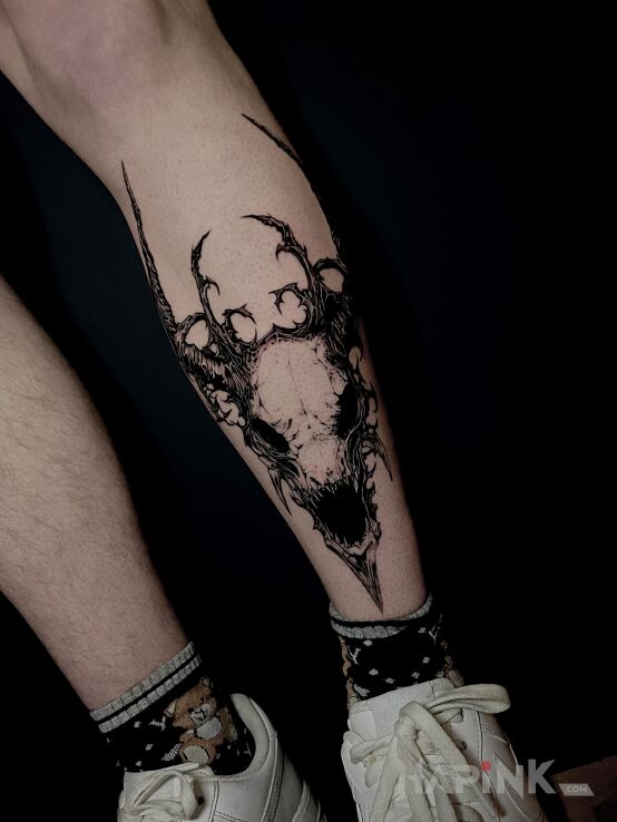 Tattoo Goat skull in black and gray motif and graphic / illustrative style on the leg