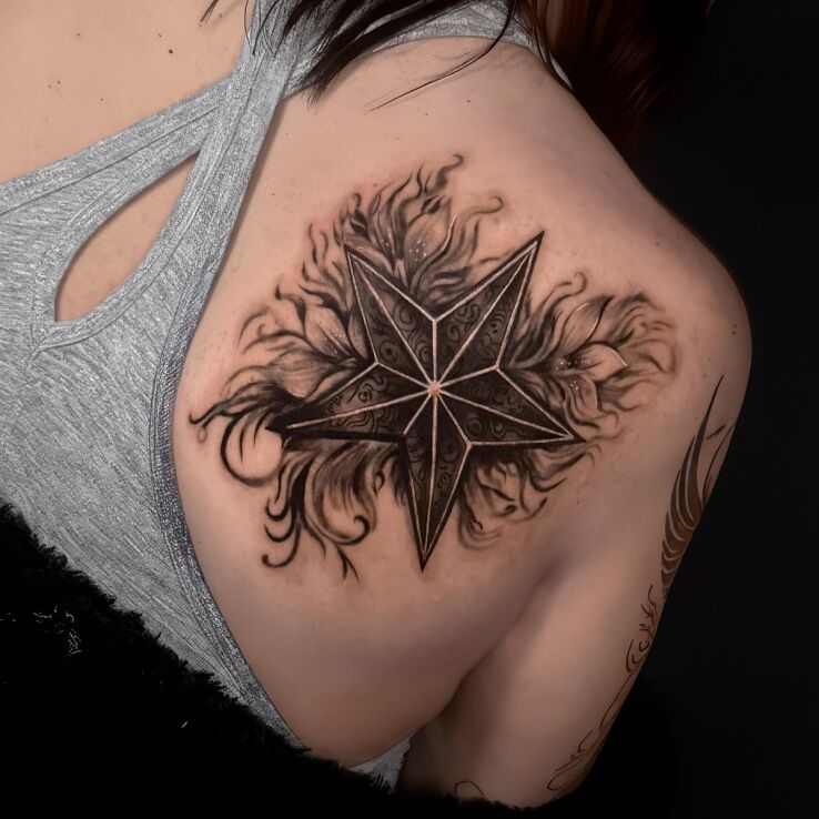 Tattoo Star against a background of leaves in black and gray motif and graphic / illustrative style on the shoulder blades