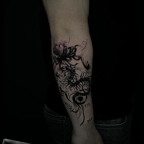 Tatuaż Skolopendra z kwiatem i liczbami na ręce motyw: czarno-szare styl: blackwork / blackout