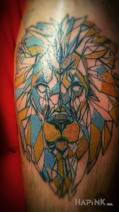 Tattoo Lew in colorful motif and geometric style on the calf