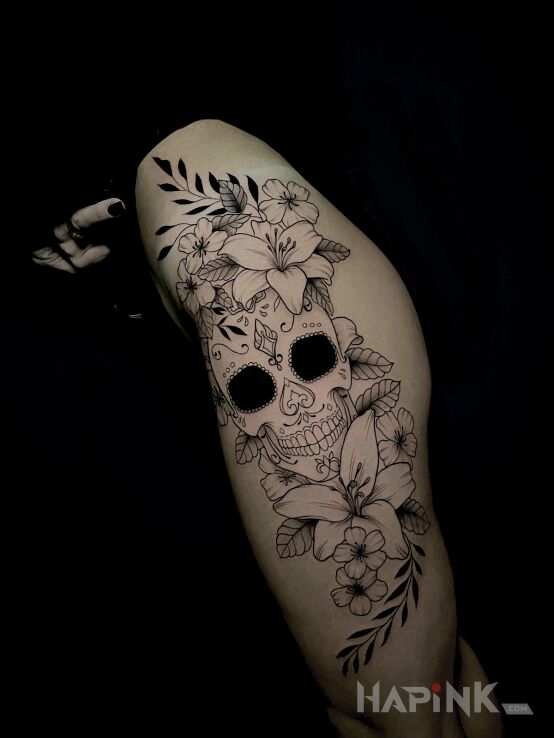 Tattoo Mexican skull with flowers in flowers motif and contour / linework style on the hip
