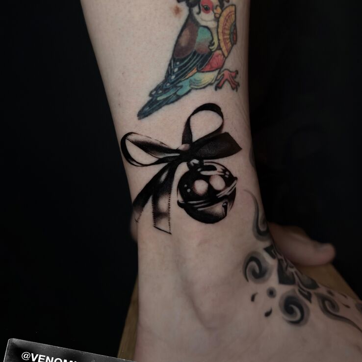 Tattoo Bell with a Bow in 3D motif and realistic style on the leg