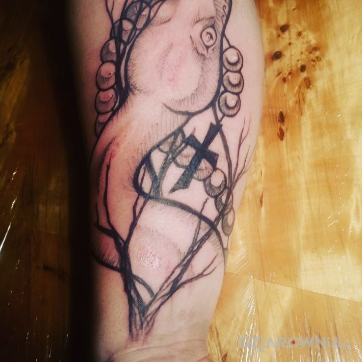 Tatuaż wąż w motywie religijne na przedramieniu