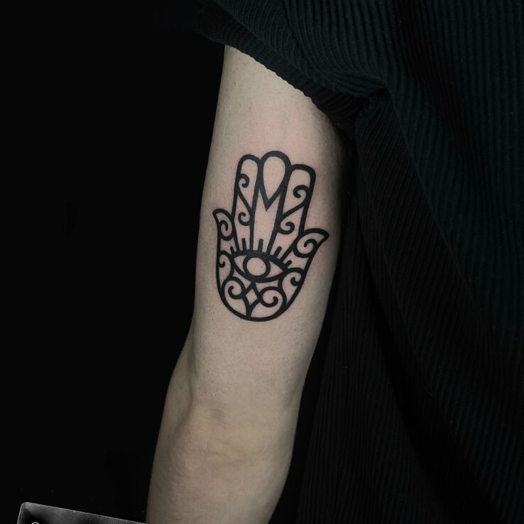 Tattoo Hamsa in black and gray motif and contour / linework style On the arm