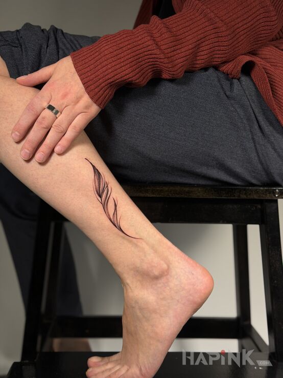 Tattoo Delicate Feather in other motif and minimalistic style on the leg