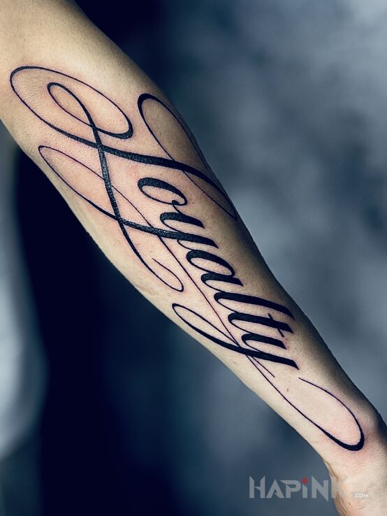 Tattoo Loyalty in lettering motif and calligraphy style on the forearm