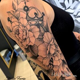 Tattoo Floral composition with crown and butterfly on the upper arm motif: black and gray style: dotwork