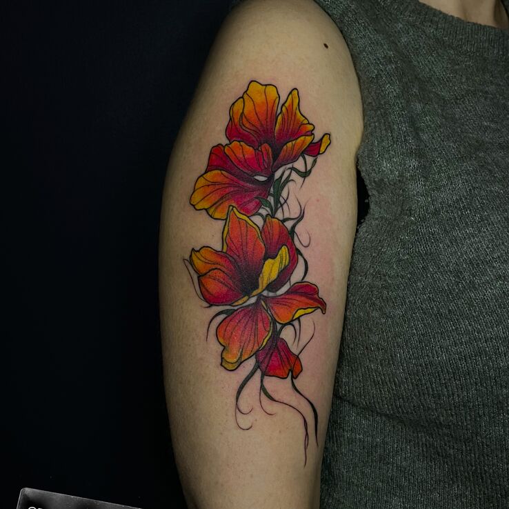 Tattoo Red and orange flowers in colorful motif and graphic / illustrative style on the upper arm