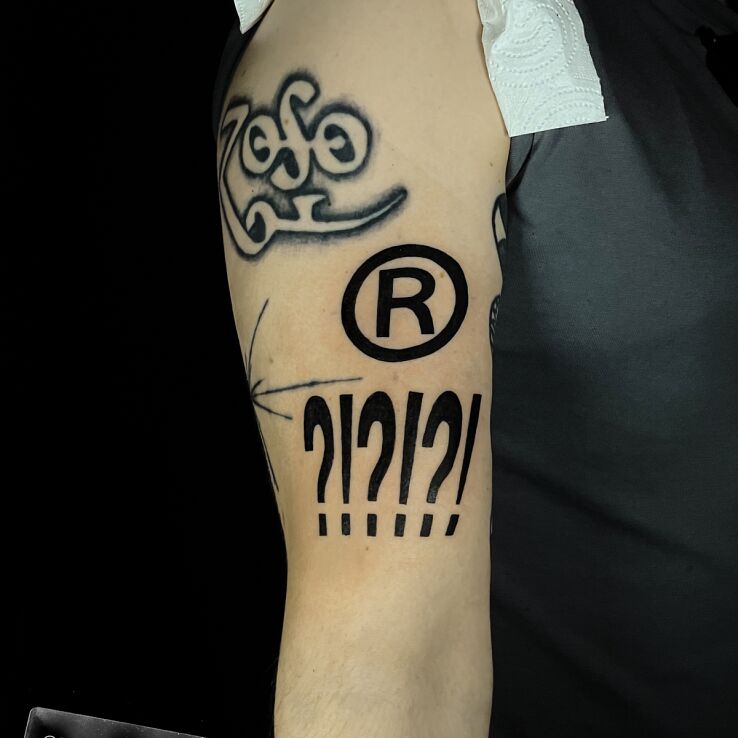 Tattoo Question marks in other motif and blackwork / blackout style On the arm