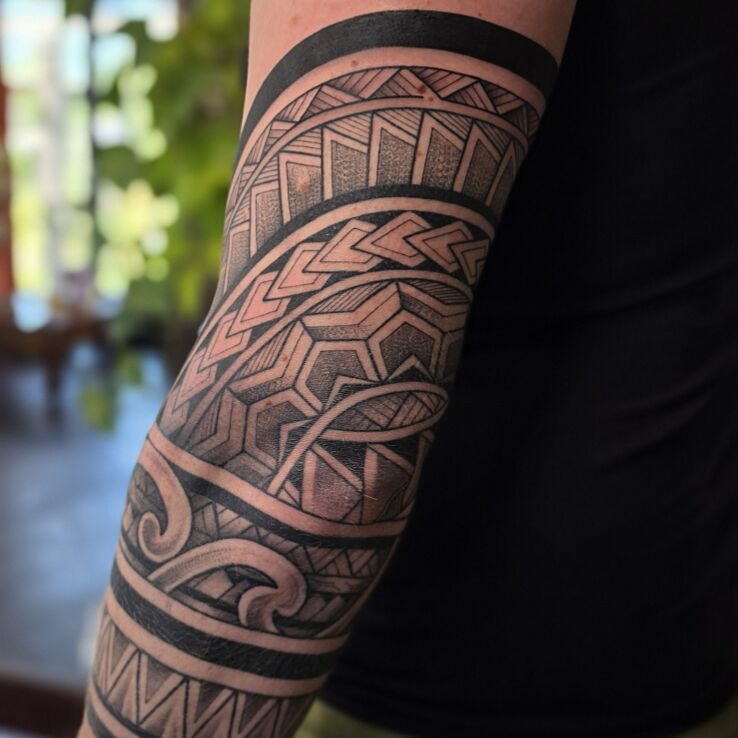 Tattoo Full elbow in Polynesian patterns in black and gray motif and Polynesian style on the bicep