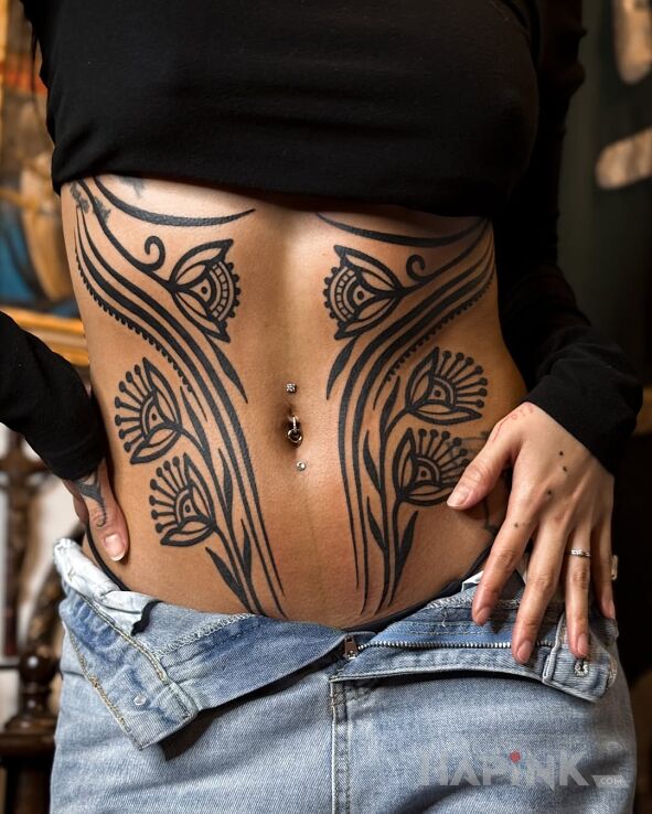 Tattoo Artistic flowers in flowers motif and blackwork / blackout style on the stomach