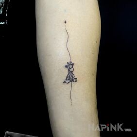 Tattoo Plush giraffe on the forearm motif: black and gray style: minimalistic