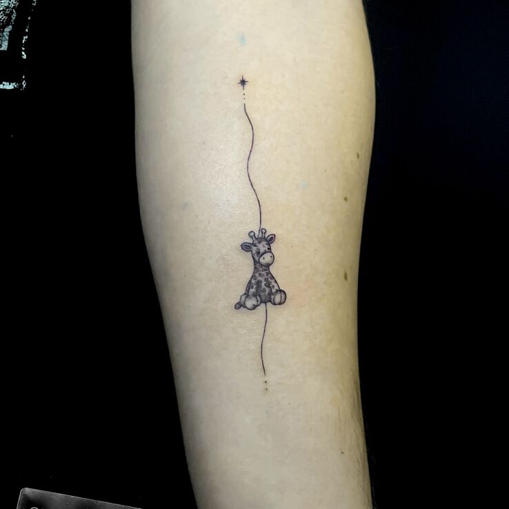 Tattoo Plush giraffe in graphic / illustrative style on the forearm