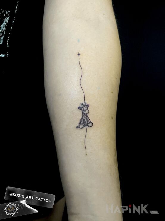 Tattoo Plush giraffe in graphic / illustrative style on the forearm
