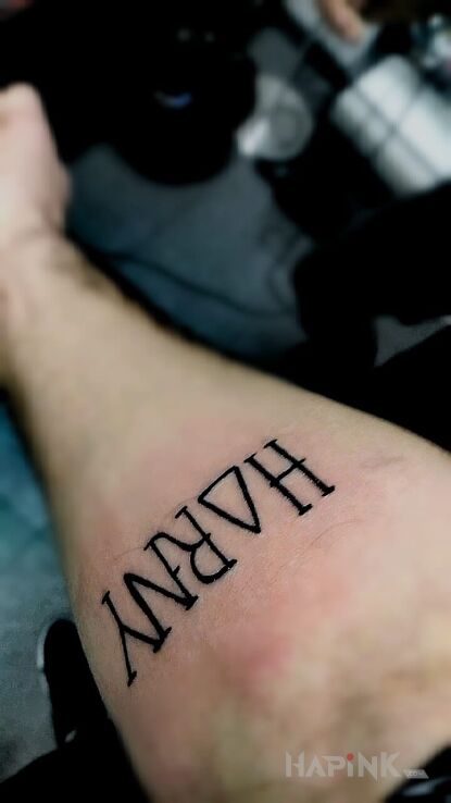 Tattoo Napis horny o zamienione na trójkąt in lettering motif on the forearm