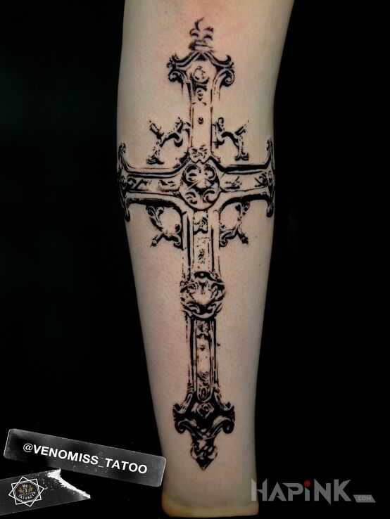 Tattoo Gothic cross in religious motif and graphic / illustrative style on the leg